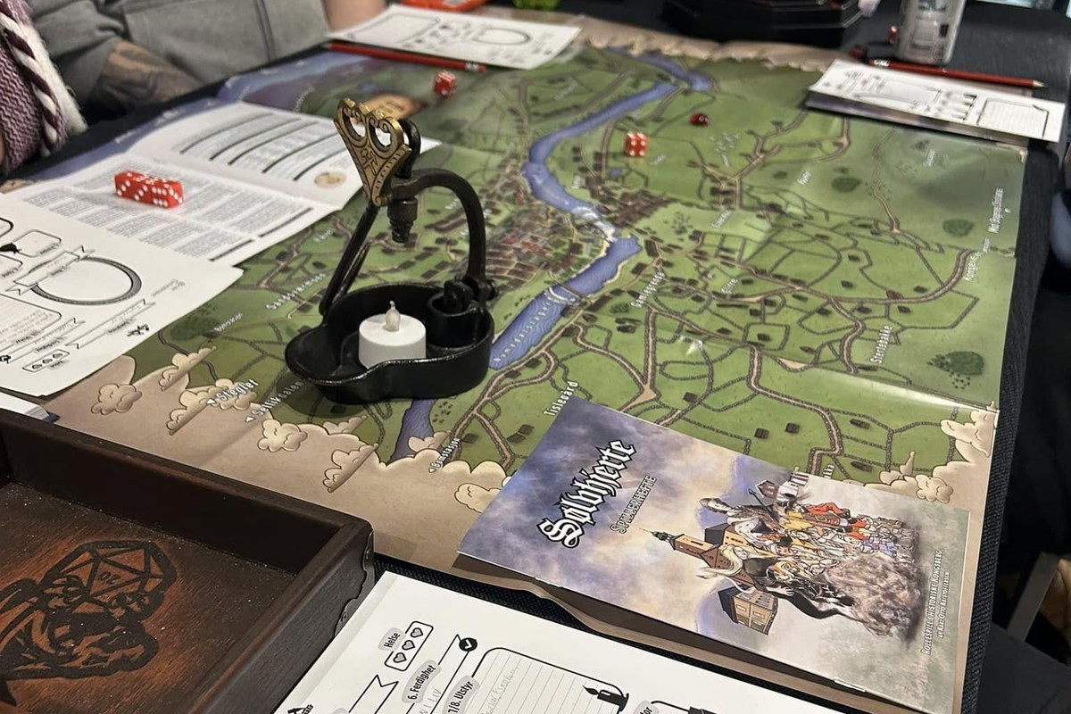 Map, player booklet, character sheets and dice on the table